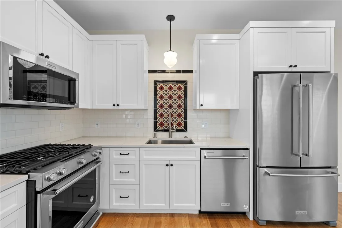 White shaker cabinetry with a decorative tile backsplash accent and stainless appliances in a transitional South Bay kitchen.